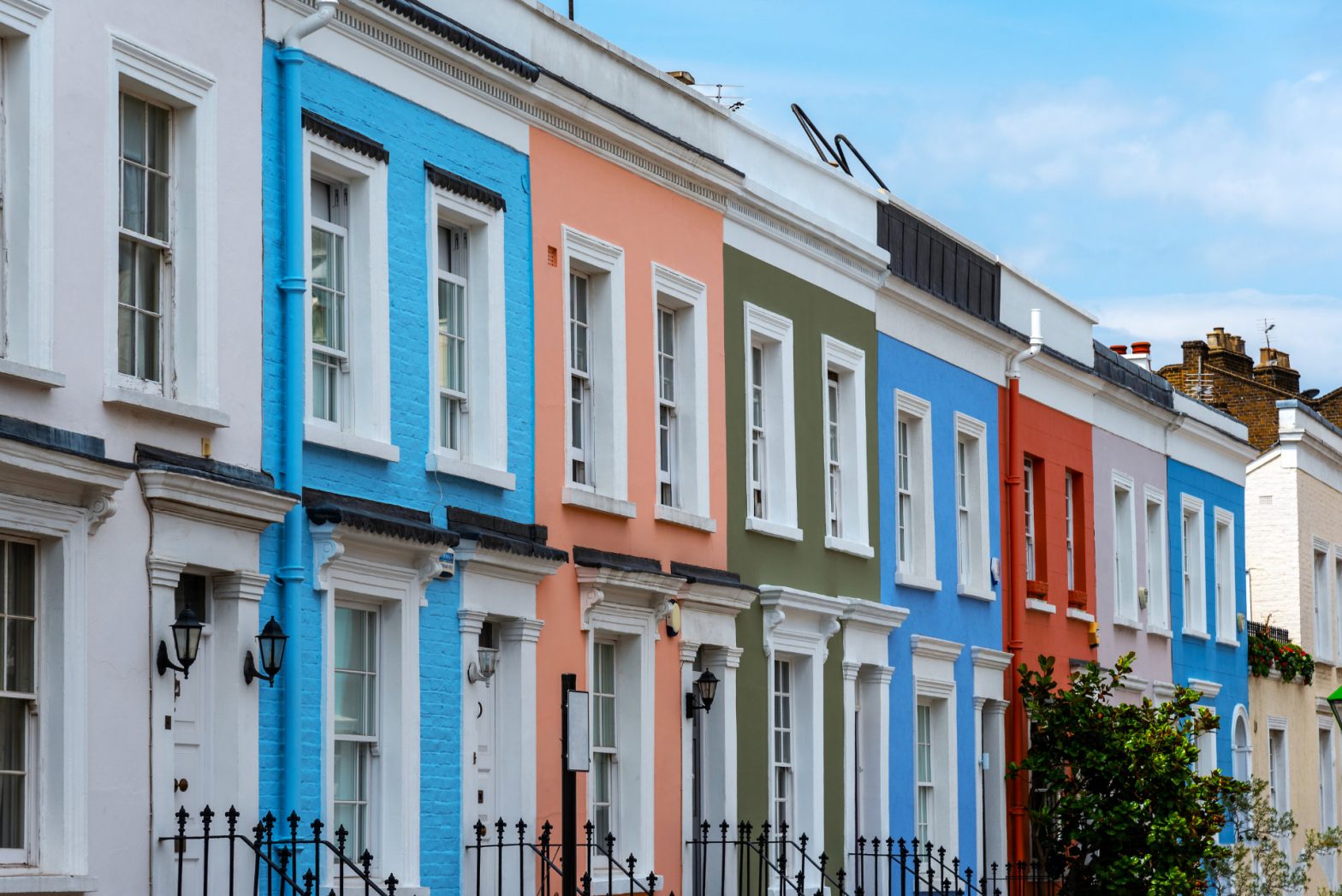 A row of colourful residential properties containing leasehold flats