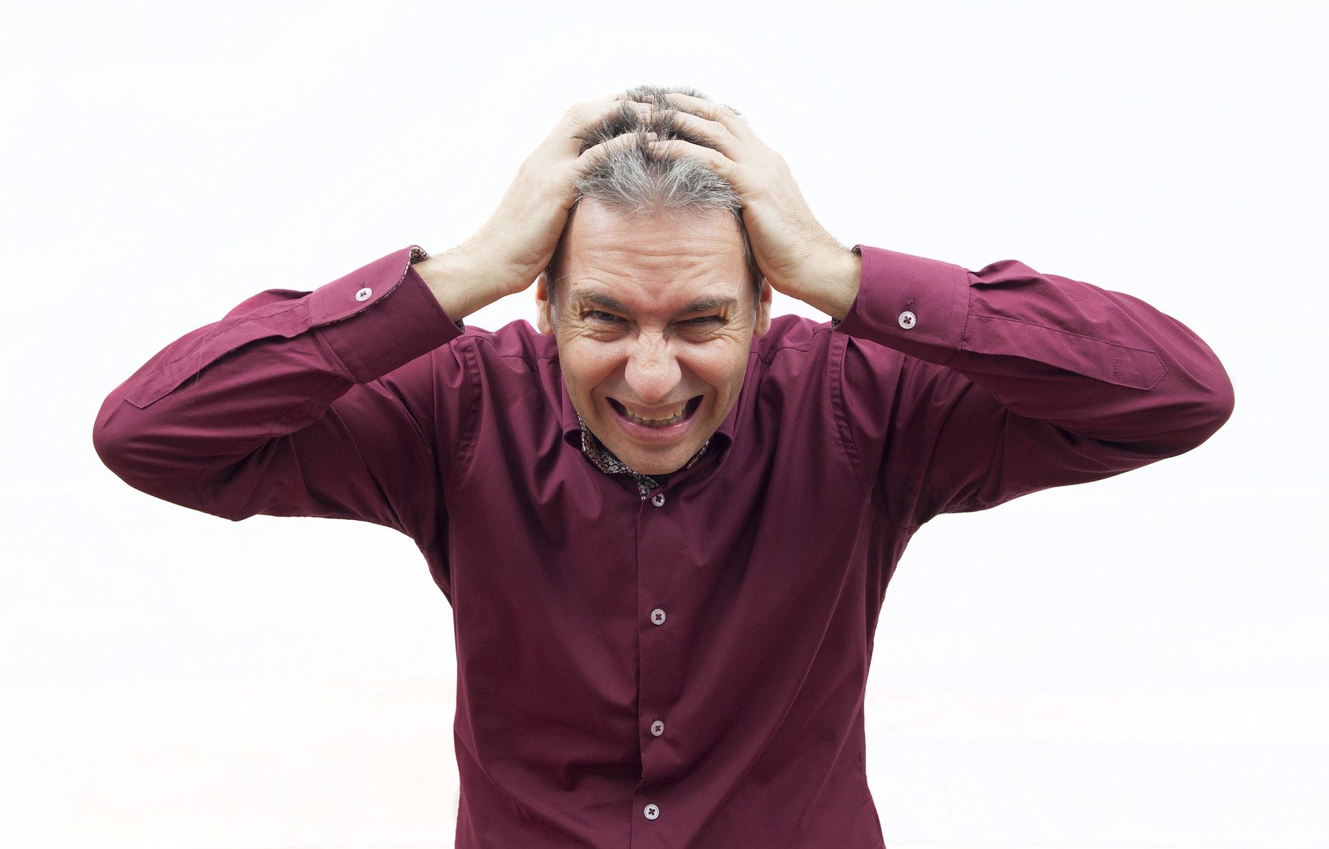 man with hands on head, feeling very stressed