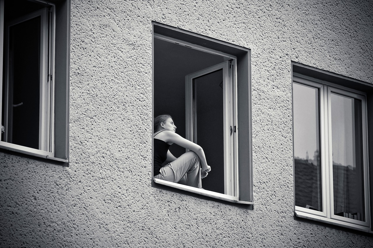 Woman sitting at her window, thinking