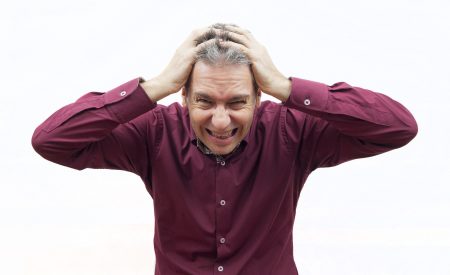 man with hands on head, feeling very stressed