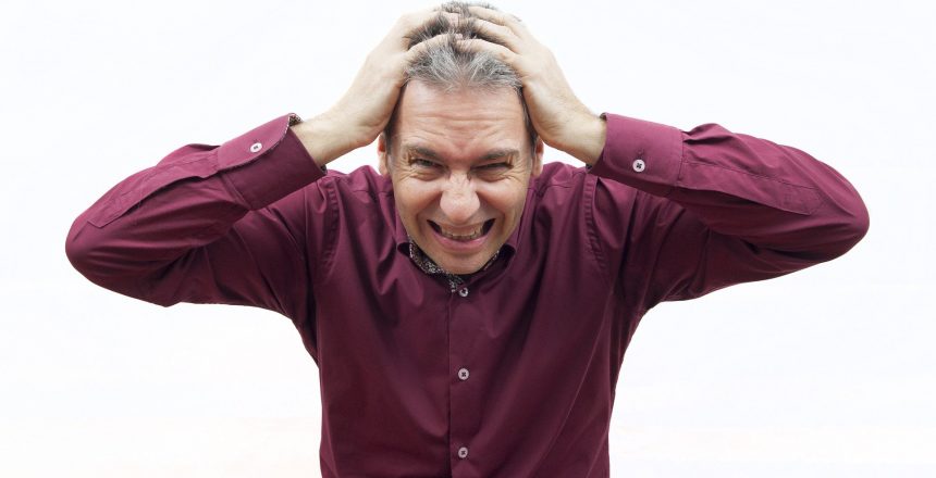 man with hands on head, feeling very stressed