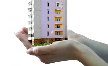 Freeholder with responsibilities holding block of flats in hands