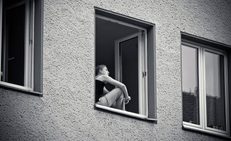 Woman sitting at her window, thinking