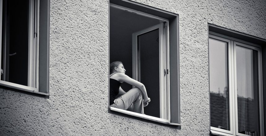 Woman sitting at her window, thinking