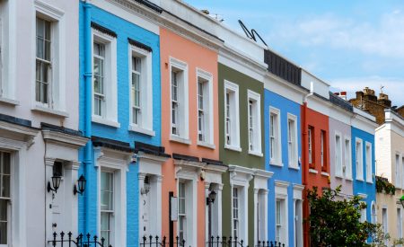 A row of colourful residential properties containing leasehold flats